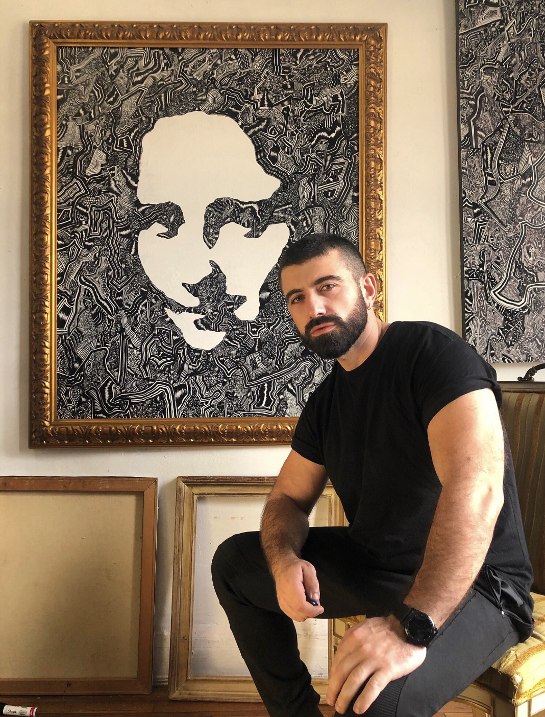 David in a black t-shirt in front of one of his paintings, a black and white rendition of the Mona Lisa