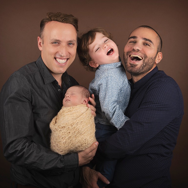 Kiviti family smiling and laughing in a portrait style family photo