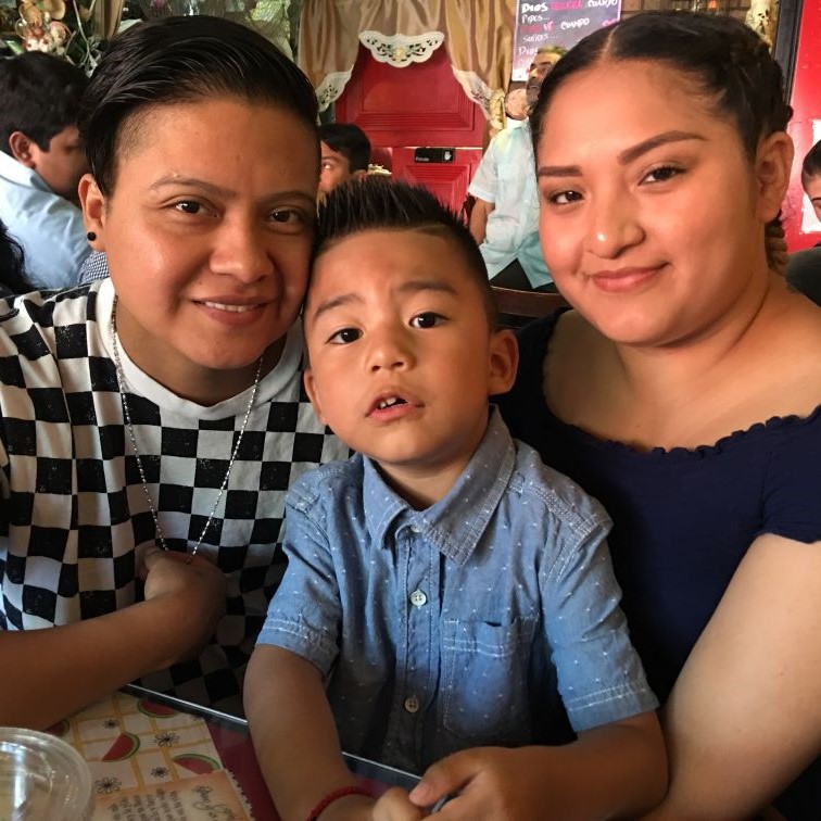 Terry and Adriana smiling, holding their son Darien